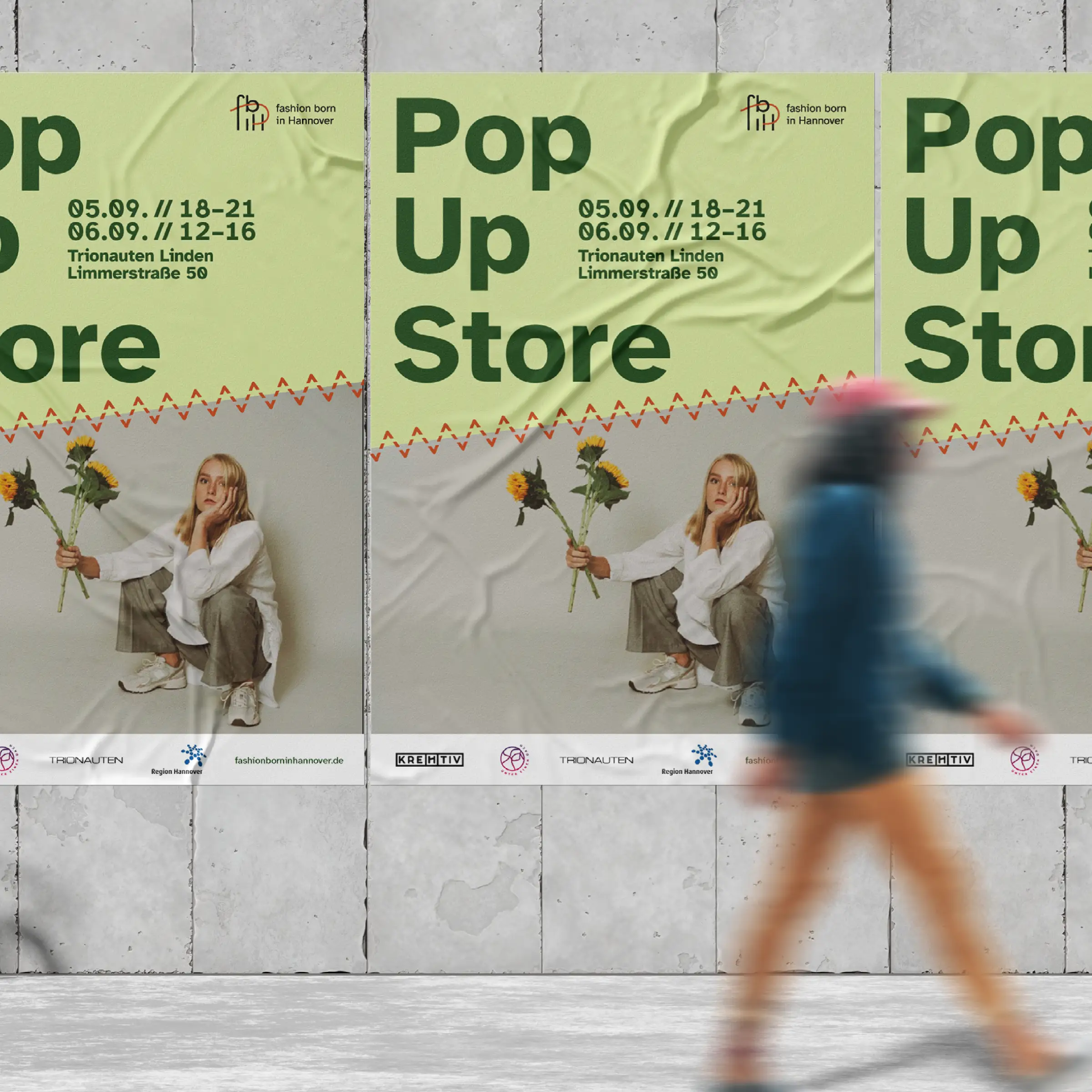 Das Foto zeigt eine graue Au&szlig;enwand mit 3 Postern. Diese sind diesselben und enthalten ein Layout mit einer Frau, welche vor einem hellen Hintergrund hockt und einen Blumenstrau&szlig; in ihrer rechten Hand h&auml;lt. Dar&uuml;ber liegt eine helle Fl&auml;che mit der Aufschrift: Pop Up Store. Vor der Au&szlig;enwand l&auml;uft eine Person, die durch ihre Bewegung verschwommen ist.
